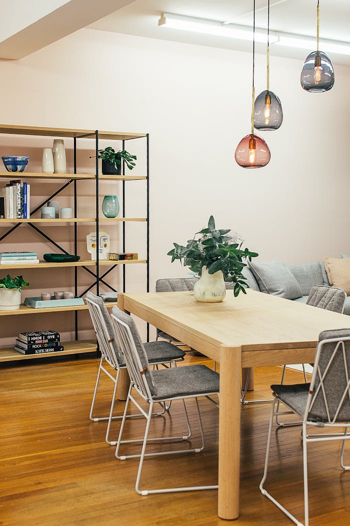 Interior of light living room with wooden table and shelves with decorative elements in modern apartment